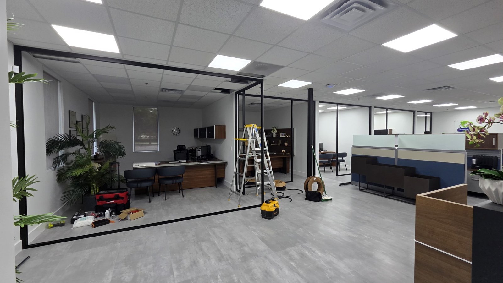 Vista general del proyecto de paredes de vidrio para Teilen en Miami, con herramientas y divisiones durante la instalación.