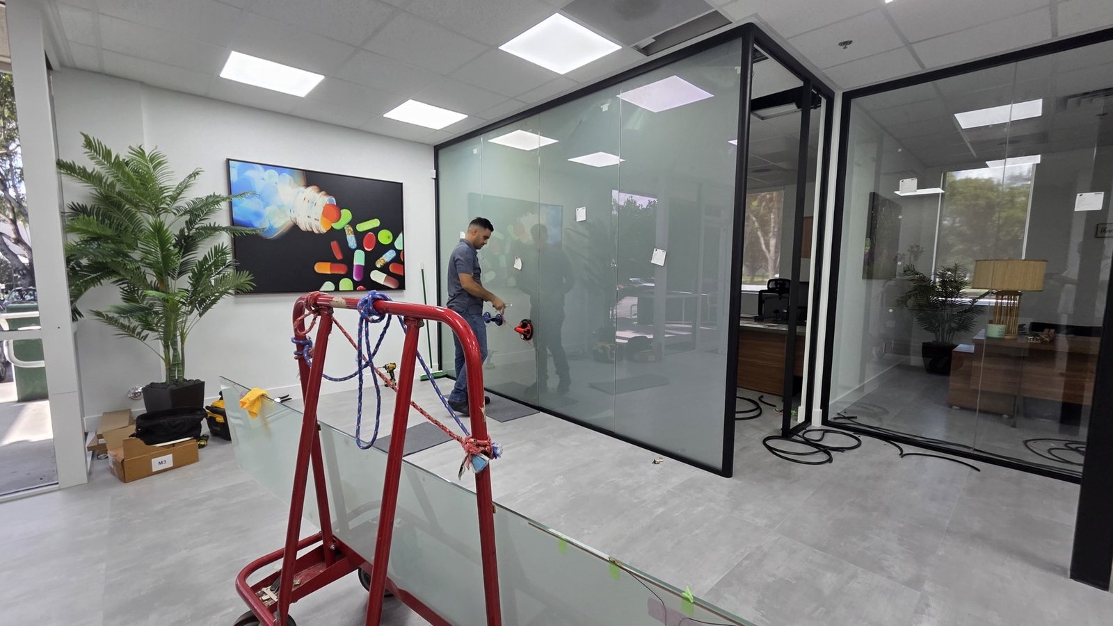 Instalador junto a una división de vidrio durante el montaje de SmartVinyl para Teilen en Miami.